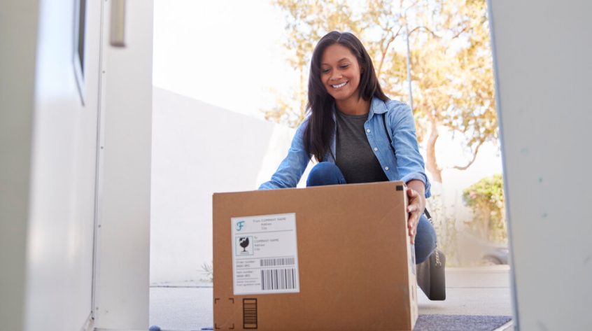 A-woman-carrying-a-box-outside-her-home